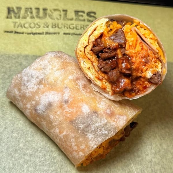 Two Naugles Tacos burritos, one cut open to show beef, rice, and cheese filling.